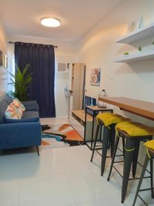 バコロドにあるChic Condo Retreat at Camella Manorのテーブルと椅子のあるリビングルーム