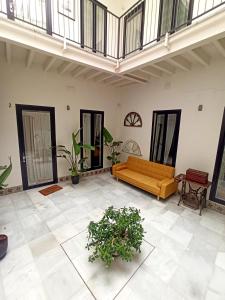 a living room with a couch and some plants at Apartamentos La Higuera by VGH in Jerez de la Frontera