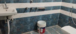 a bathroom with a sink and a blue and white tiled wall at Hari Krishna Sadan paying guest House AYODHYA DHAM RAILWAY STATION in Faizābād