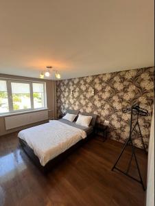 a bedroom with a large bed with a wall at LUNA Apartamentai in Akmenė