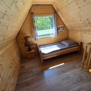 a bedroom in a log cabin with a window at Borówkowa Agroturystyka Nad Morzem in Darłowo