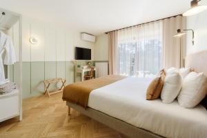 塔卢瓦尔Hôtel Le Mouton Bleu的带一张大床和一扇窗户的卧室