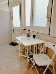 a white table and chairs in a room with a window at Aleila in Bacoli
