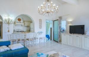 a living room with a chandelier and a blue couch at Pet Friendly Home In Stintino in Stintino