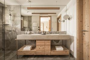 un bagno con lavandino e doccia di Falkensteiner Hotel Kronplatz - The Leading Hotels of the World a Brunico
