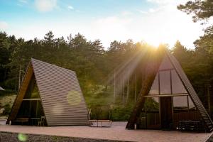 two houses with the sun shining between them at Surami Savannah სურამი სავანა in Surami