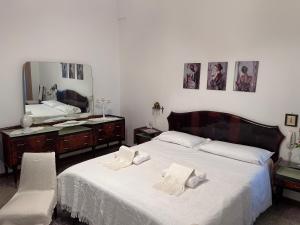 a bedroom with two beds and a dresser and a mirror at Il Giardino Segreto in Maglie