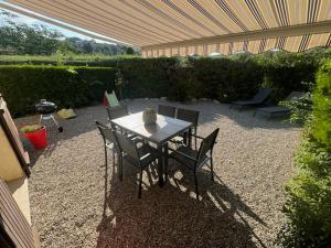 a patio with a table and chairs in a backyard at Lou Figoun in Gréoux-les-Bains
