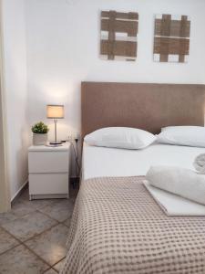 a bedroom with a bed and a night stand with a lamp at Feidiou 1 vol II in Aegina Town