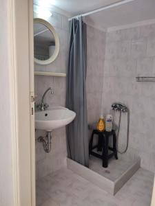 a bathroom with a sink and a shower curtain at Feidiou 1 vol II in Aegina Town