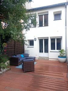 a patio with two couches and a fence at Gite Les 4 Fleurs in Le Puy en Velay