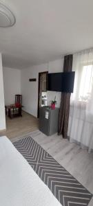 a room with a bed and a living room with a table at CASA RYANA SINAIA in Sinaia