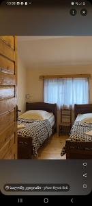 a bedroom with two beds and a window at Dali Kaldanis Guest House in Becho in Mestia