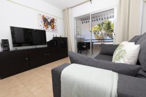 Una sala de estar con un sofá y un televisor de pantalla plana. en PARAISO DREAMS, en Playa Paraiso