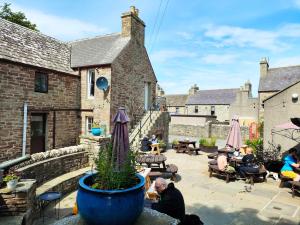 a group of people sitting around a patio at St Margaret's Hope Backpackers Hostel in Orkney