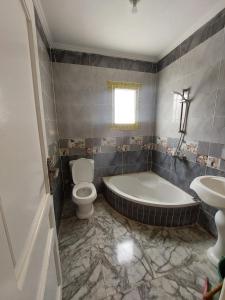 a bathroom with a tub and a toilet and a sink at شاليه سوبر لوكس in El Alamein