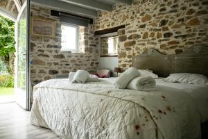 una camera con un grande letto in una parete in pietra di Gîte Les Dalias a La Porcherie