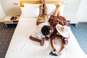 two people laying on a bed at Stay Hotel Guimarães Centro in Guimarães
