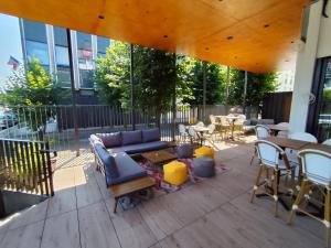 a patio with a couch and tables and chairs at ibis Le Havre Centre in Le Havre