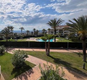 a courtyard with palm trees and a swimming pool at Torresnostra see experience in Torreblanca