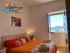 a bedroom with a bed with orange sheets and a window at Casa Marea Sperlongaresort apartment in Sperlonga