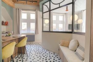 a living room with a couch and a table and two chairs at LaBolla, charmant cocon avec spa, cœur de Lyon in Lyon +21 photos