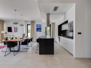 a kitchen and dining room with a table and a tv at Villa Inizio by Interhome in Brodarica