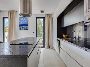 a kitchen with white cabinets and black countertops at Villa Inizio by Interhome in Brodarica