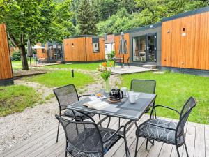 a table and chairs on a deck with a house at Holiday Home Tiny Haus Auszeit by Interhome in Riedenburg