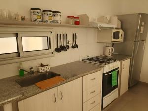 a kitchen with a sink and a stove top oven at Heart Depto 1 Viedma Centro Confortable y Optima Ubicación in Viedma
