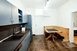 a kitchen with blue cabinets and a wooden table at Casa Leonhardt in Sighişoara
