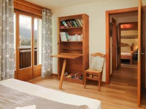 a bedroom with a desk and a chair and a window at Apartment Résidence 25 by Interhome in Champex