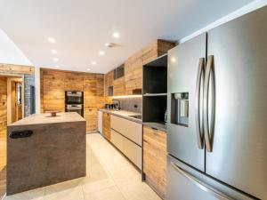 a kitchen with a stainless steel refrigerator and wooden walls at Apartment Le Canvolan by Interhome in Tignes
