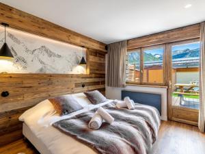 a bedroom with a large bed and a large window at Apartment Le Canvolan by Interhome in Tignes