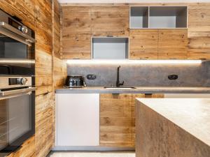 a kitchen with a sink and wooden walls at Apartment Le Canvolan-1 by Interhome in Tignes