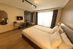 a hotel room with a large white bed and a desk at East Sliema Suites in Sliema