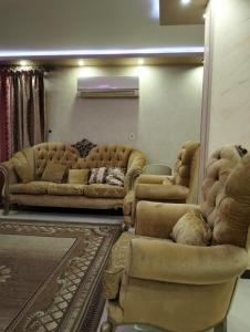 a living room with two couches and a mirror at Ganna Misr in Cairo
