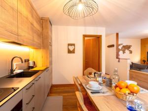 a kitchen with a table with a bowl of oranges on it at Apartment Ca' di nonón by Interhome in Penia