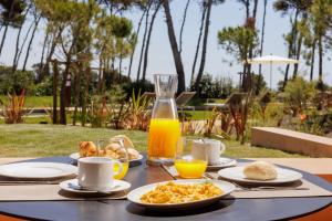 a table topped with plates of food and orange juice at Palmares Signature Apartments in Lagos