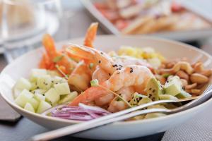 a bowl of food with shrimp and vegetables on a table at Palmares Signature Apartments in Lagos
