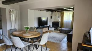 a living room with a dining room table and chairs at Bran Place La Odaie in Şimon