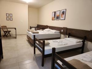 a room with four beds and a table and chairs at O Franciscano Hospedagem in Cachoeira Paulista