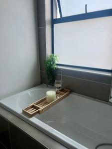 a bath tub with a candle and a glass of wine at Ballito Village Suites in Ballito