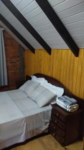 ein Bett mit weißen Laken und Kissen auf einem Tisch in der Unterkunft Quarto Coralina - Bio Cult in Campo Alegre + 13 Fotos