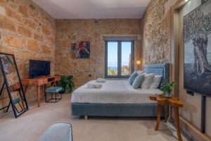 a bedroom with a bed and a window and a desk at Cavos Luxury Apartments in Kissamos
