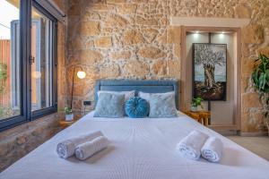 a stone walled bedroom with a large bed with pillows at Cavos Luxury Apartments in Kissamos +103 photos
