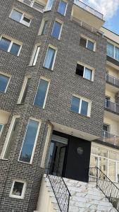 un edificio de ladrillo con una escalera delante de él en Kaya residence, en Mamaia Nord – Năvodari