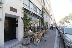 ハイファにあるStylish Modern Studios - Port & Beach Apartments, Haifaの二人の女性が店の外の椅子に座っている