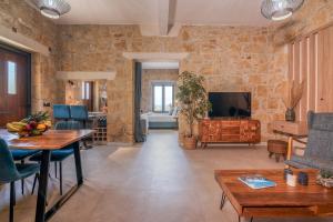 a living room with a stone wall at Cavos Luxury Apartments in Kissamos