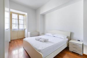 a bedroom with a white bed with two towels on it at Residenza Duomo in Alba